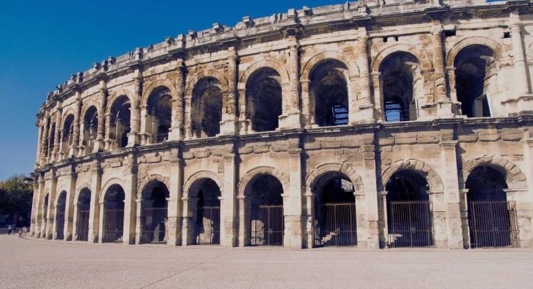Amphitheatre romain en pierre avec deux etages d arcades sous un ciel bleu