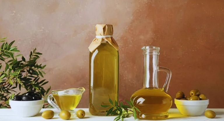 Bouteille et carafe d'huile d'olive entourées de bols d'olives vertes et noires