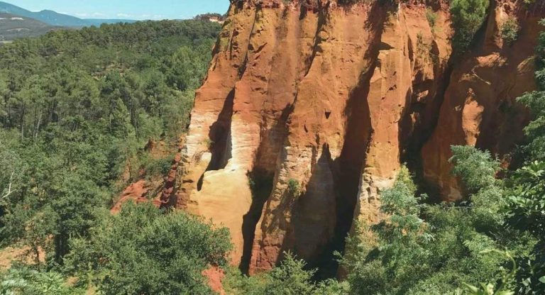 Falaises d'ocre rouge et orangé entourées de pins dans le Vaucluse