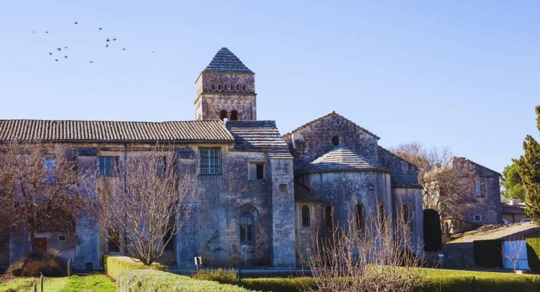 Monastere roman en pierre avec clocher carre et abside sous un ciel bleu