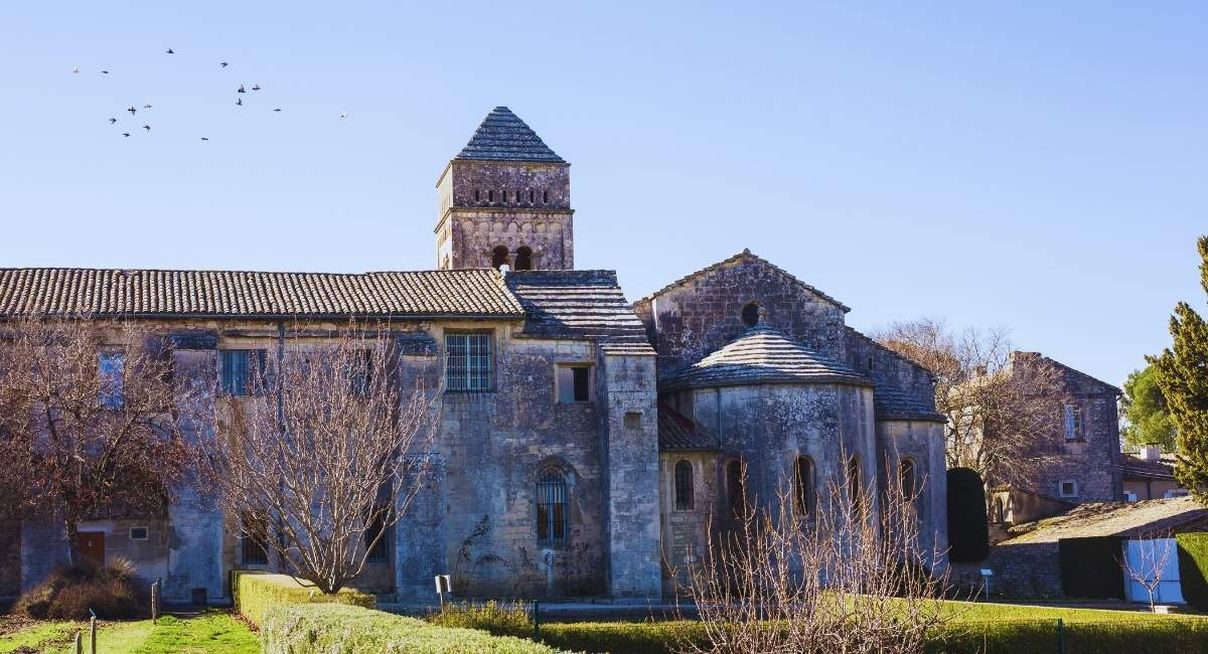 Monastere roman en pierre avec clocher carre et abside sous un ciel bleu