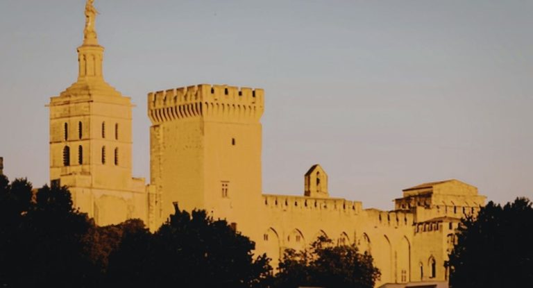 Tours crénelées du Palais des Papes d'Avignon dorées par le soleil couchant