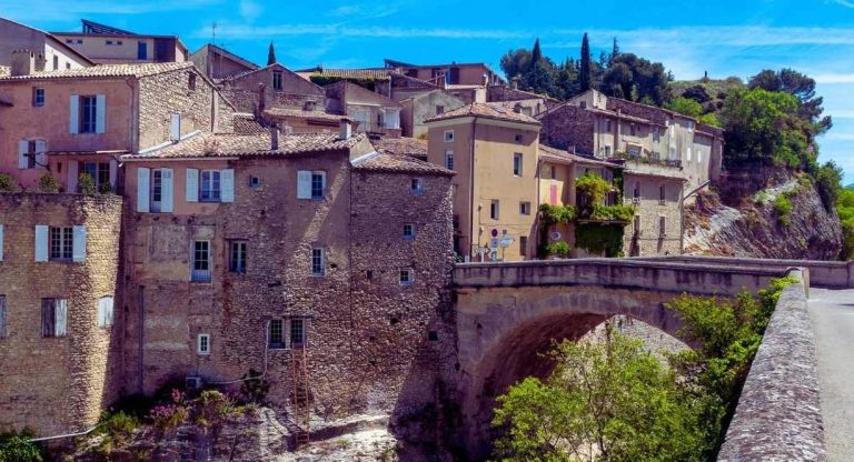 Pont de pierre en arche au pied des maisons en pierre d un village medieval