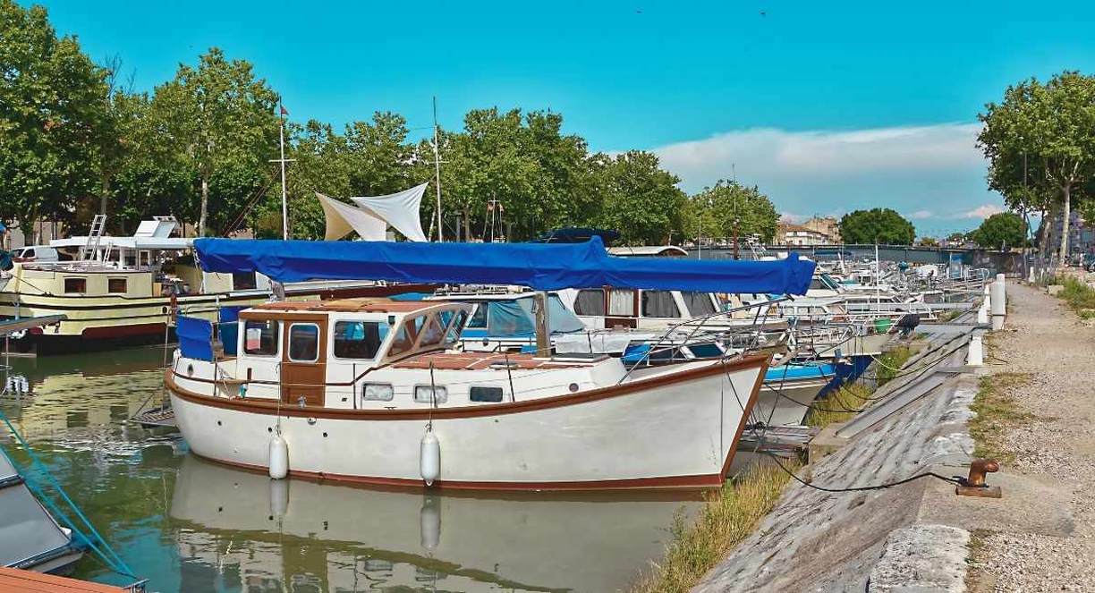 Bateaux de plaisance amarres le long d un quai de port fluvial borde de platanes