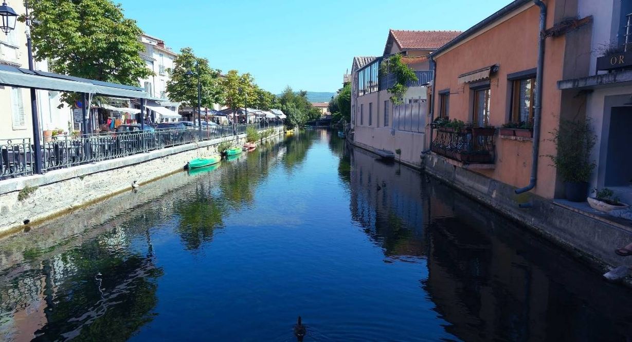 Riviere traversant un village avec des quais des terrasses et des barques