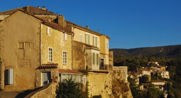 Maisons en pierre du village de Ménerbes face aux collines du Luberon